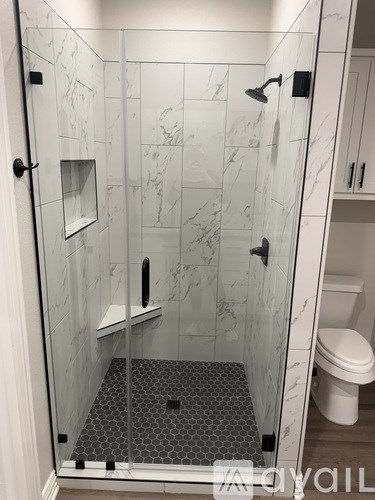 A white bathroom with a marble shower.