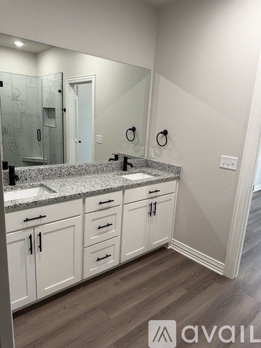 A bathroom with a granite countertop and white cabinets.