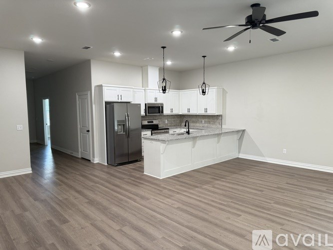 A spacious kitchen with a refrigerator, microwave, and oven.