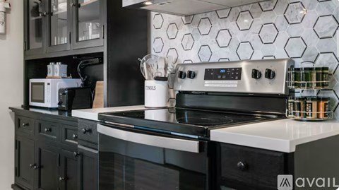 A modern kitchen with a black stove top oven and a microwave on the counter.
