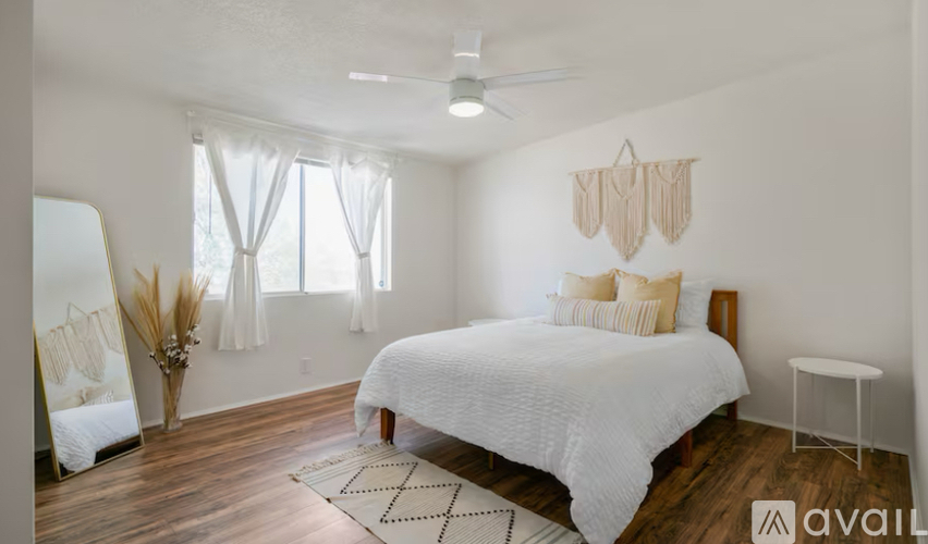 A bedroom with a large bed and a ceiling fan.