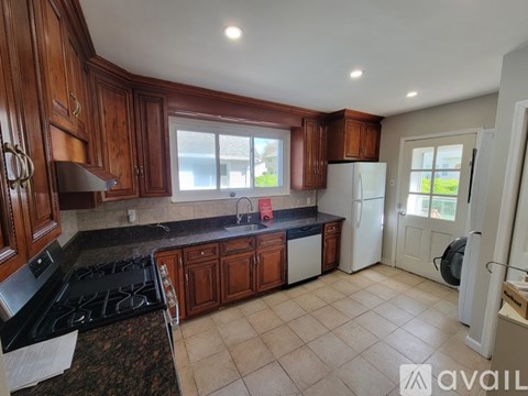 A kitchen with wooden cabinets and a black stove top.