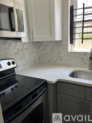 A kitchen with a black stove top oven and a white counter top.