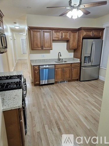 A kitchen with wooden cabinets and a stainless steel refrigerator.