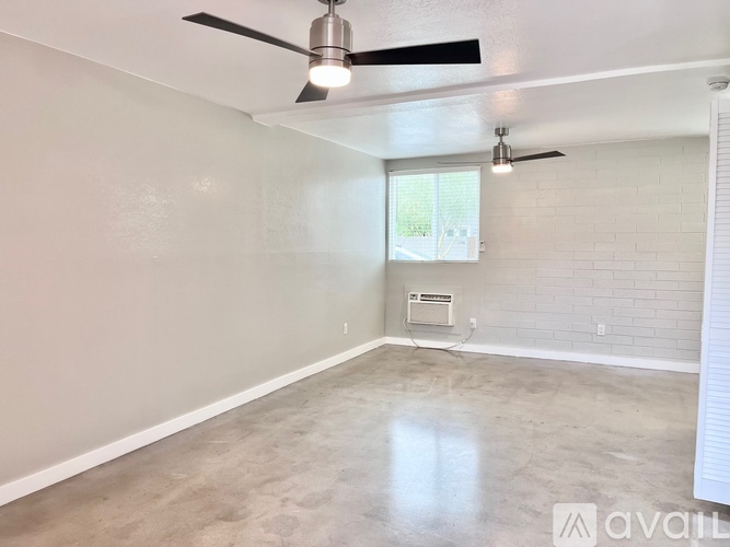 A spacious room with a ceiling fan and a window.