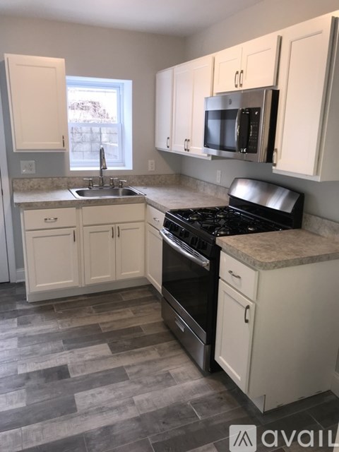 A kitchen with white cabinets and a black stove top oven.