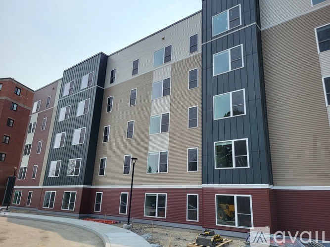 A large multi-story building with a mix of red, beige, and black exterior colors.