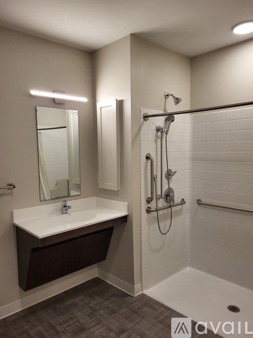 A bathroom with a white sink and a shower with a glass door.
