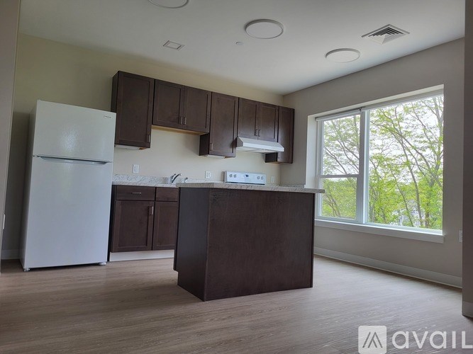 A kitchen with brown cabinets and a white refrigerator.