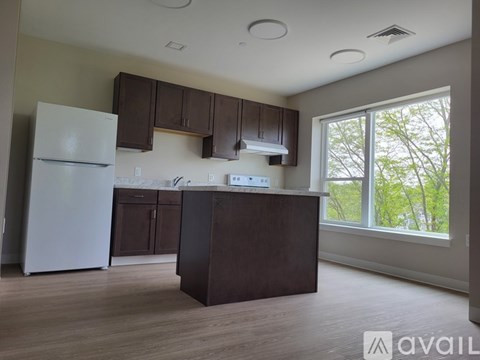 A kitchen with brown cabinets and a white refrigerator.