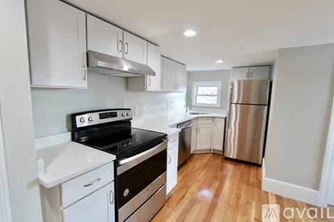 A kitchen with white cabinets and a stainless steel refrigerator.