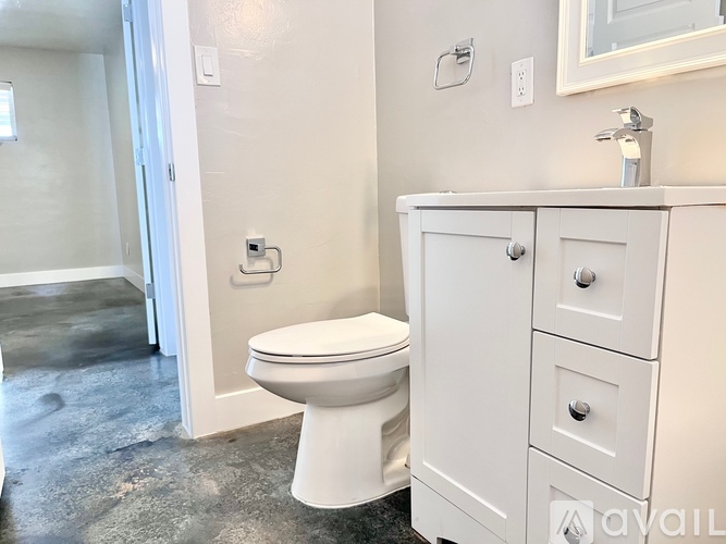 A white toilet sits next to a white cabinet in a bathroom.