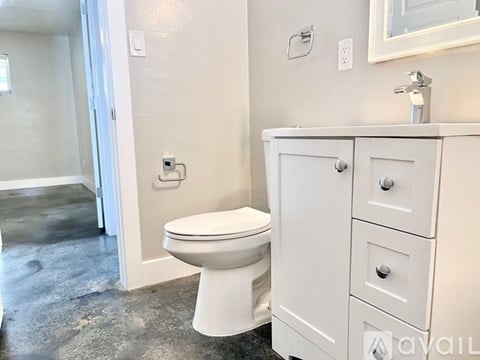A white toilet sits next to a white cabinet in a bathroom.