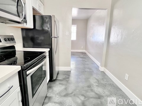 A kitchen with black appliances and white cabinets.