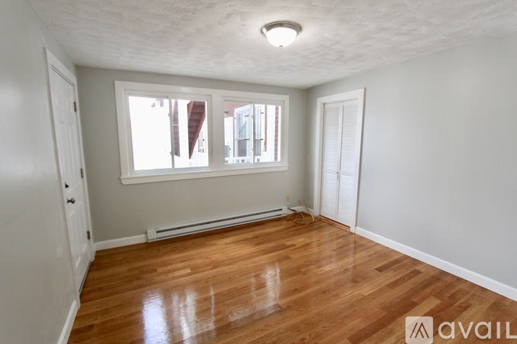 A room with wooden floors and a window letting in light.