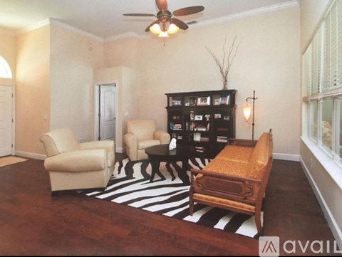 A living room with a zebra print rug and a black bookcase.