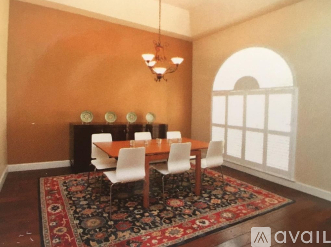 A dining room with a wooden table and chairs.