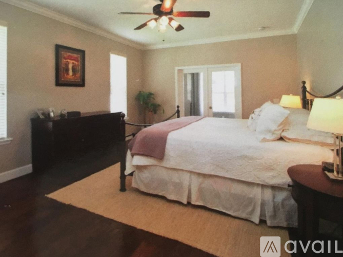 A bedroom with a bed, dresser, and ceiling fan.