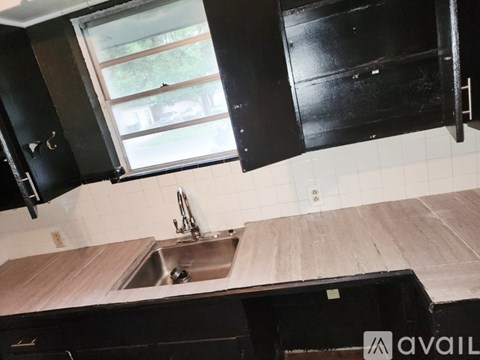 A kitchen with black cabinets and a wooden countertop.