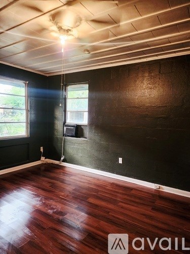 A room with wooden floors and a ceiling fan.