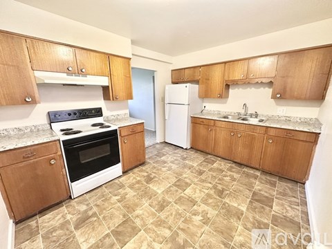 A kitchen with wooden cabinets and a tiled floor.