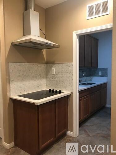 A kitchen with a stove top oven and a range hood.
