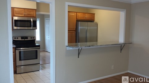 A kitchen with a refrigerator and a microwave.
