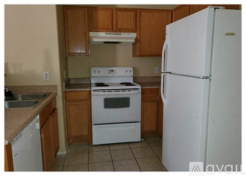 A kitchen with white appliances and wooden cabinets.
