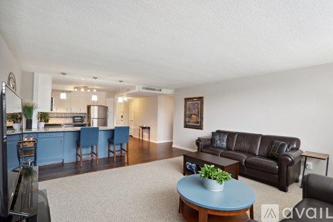 A living room with a blue table and a black couch.