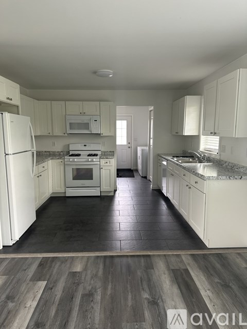 A kitchen with white appliances and cabinets.