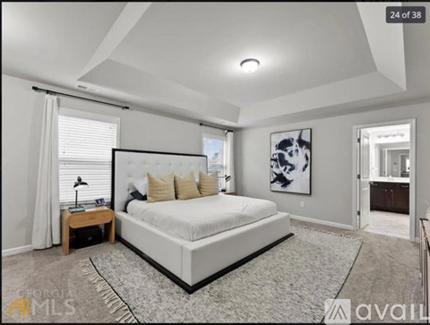 A bedroom with a large bed and a painting on the wall.