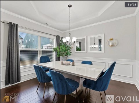 A dining room with a white table and blue chairs.