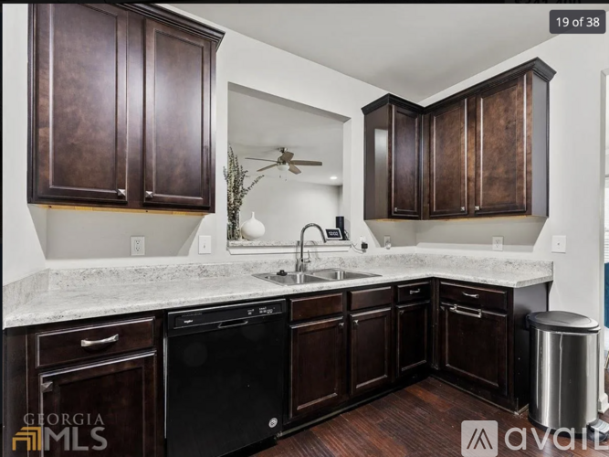 A kitchen with dark brown cabinets and a white counter top.