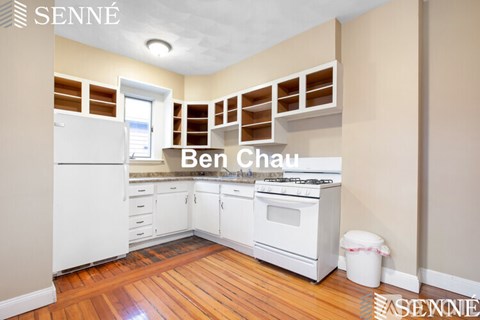 A kitchen with white appliances and wooden floors.