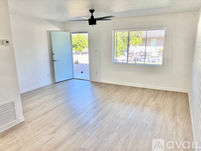 A room with a ceiling fan and a door leading outside.