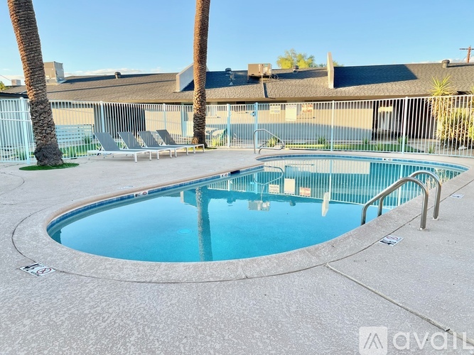 A round above ground pool with a concrete floor and a metal fence around it.