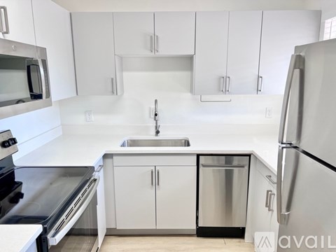 A kitchen with white cabinets and stainless steel appliances.