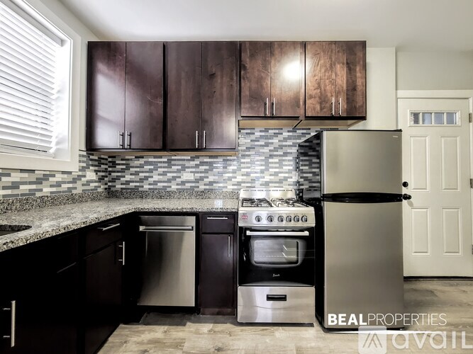 A kitchen with dark wood cabinets and a stainless steel refrigerator.