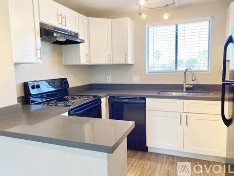 A kitchen with white cabinets and a black dishwasher.