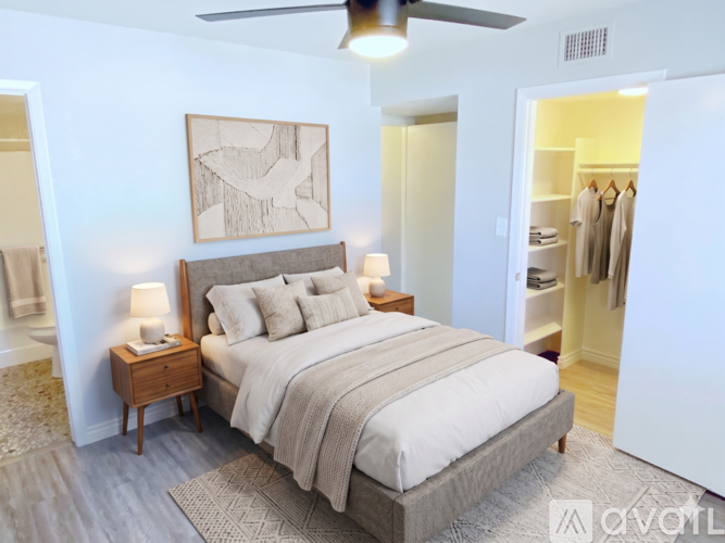 A bedroom with a large bed and a ceiling fan.
