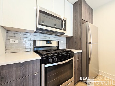 A kitchen with a black stove top oven and a microwave above it.
