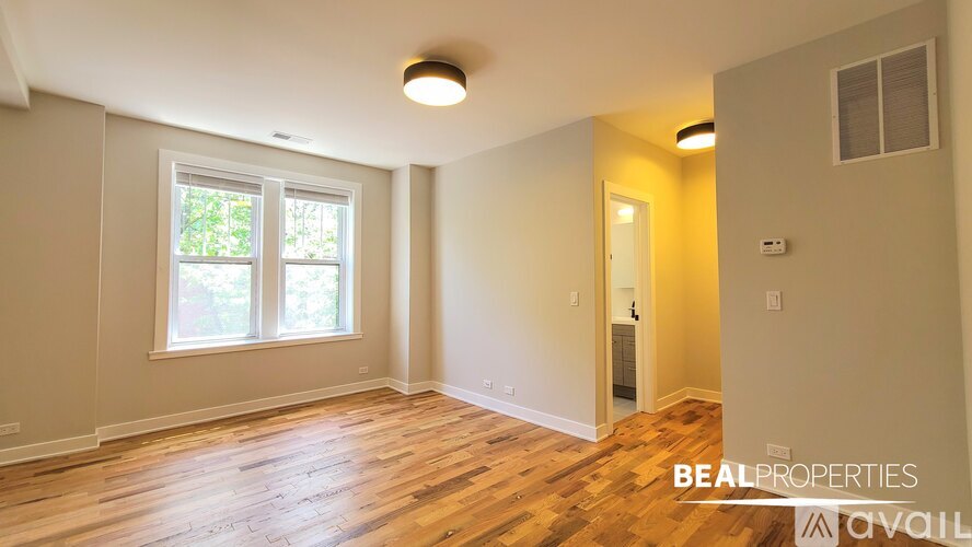 A kitchen with white cabinets and a stainless steel refrigerator.