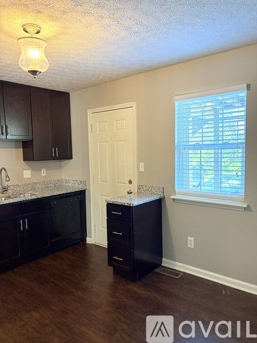 A kitchen with dark wood cabinets and a white door.
