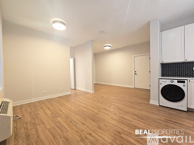 A room with a washing machine and a wall heater.
