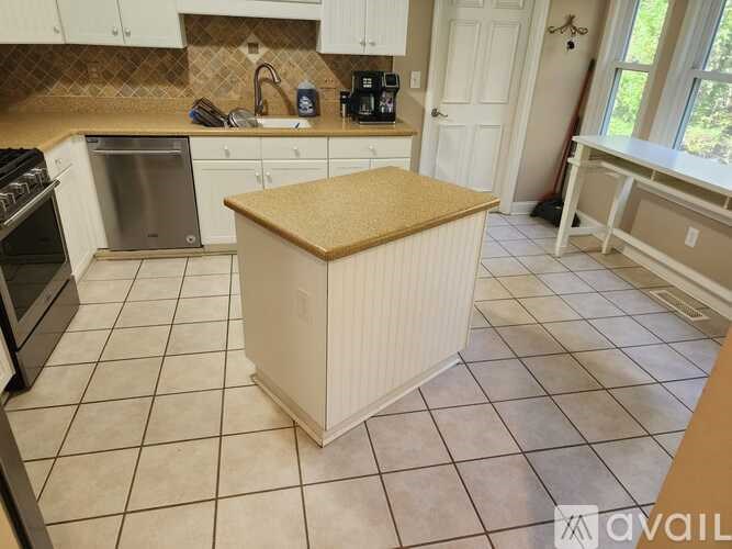 A kitchen with a white stove and a white dishwasher.