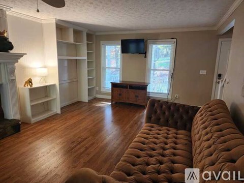 A living room with a brown couch and a fireplace.