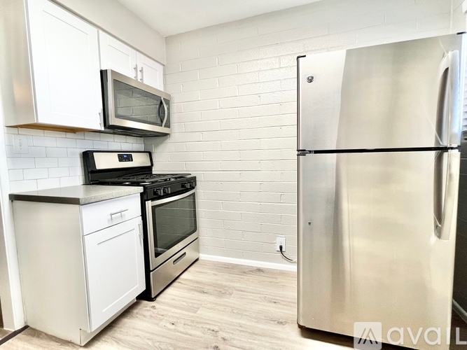 A kitchen with a stove, oven, microwave, and refrigerator.