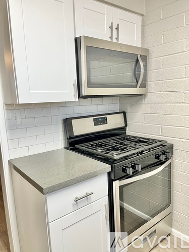 A kitchen with a stove and microwave above it.