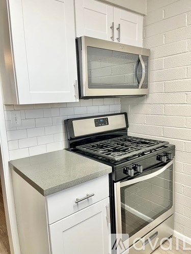 A kitchen with a stove and microwave above it.
