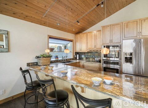 A kitchen with wooden cabinets and a granite countertop.